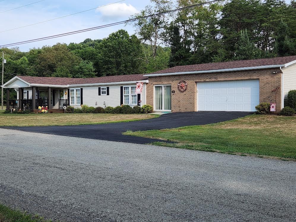 a front view of a house with a yard and trees