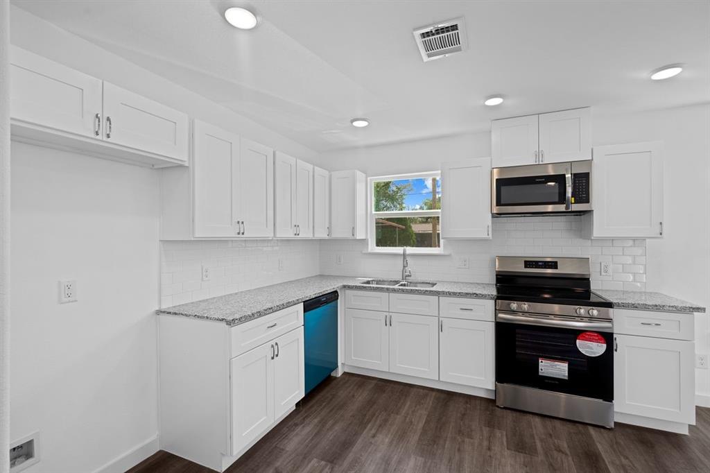 a kitchen with sink a microwave and cabinets