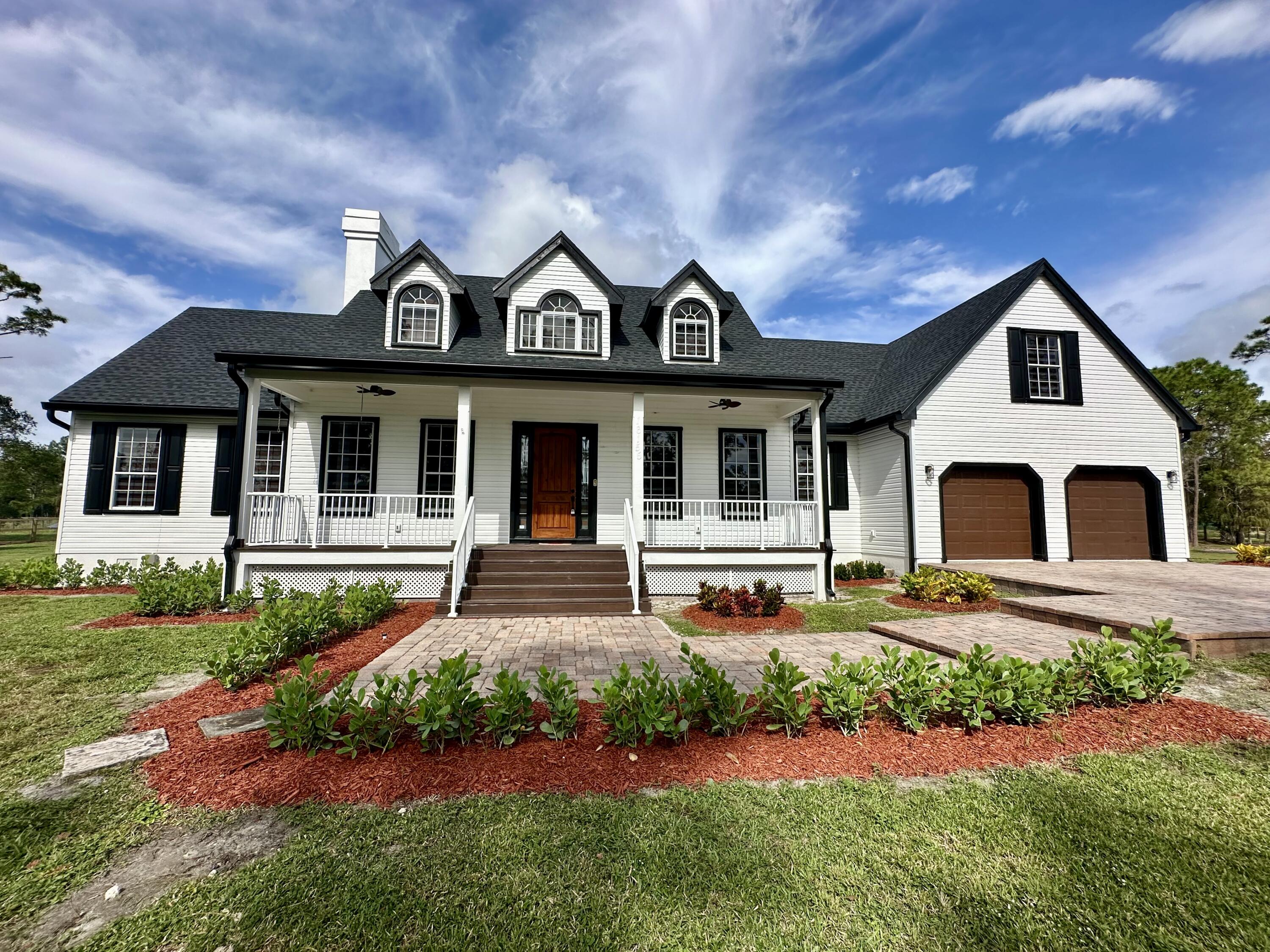 a front view of a house with yard and green space