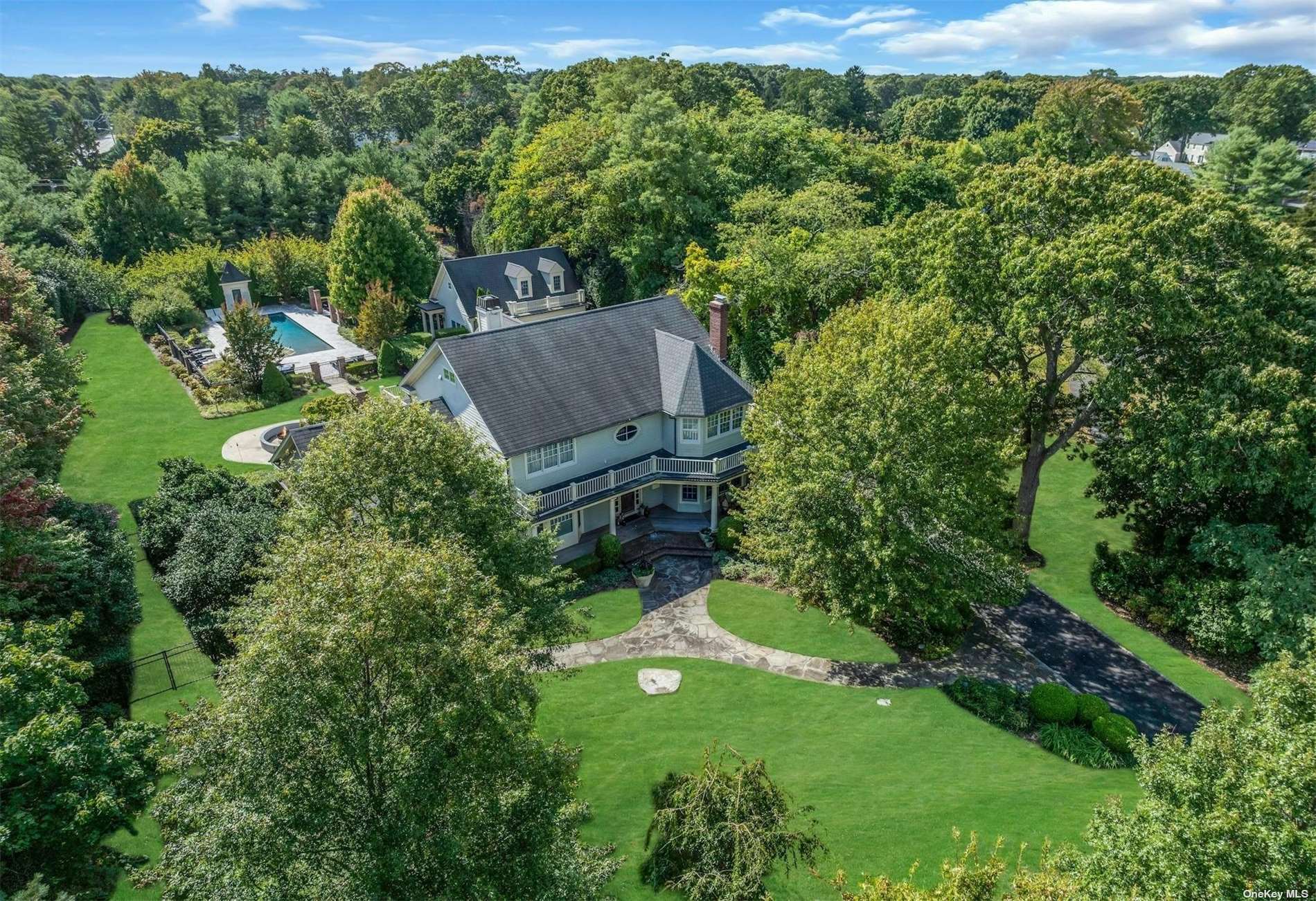 an aerial view of residential house with outdoor space and trees all around