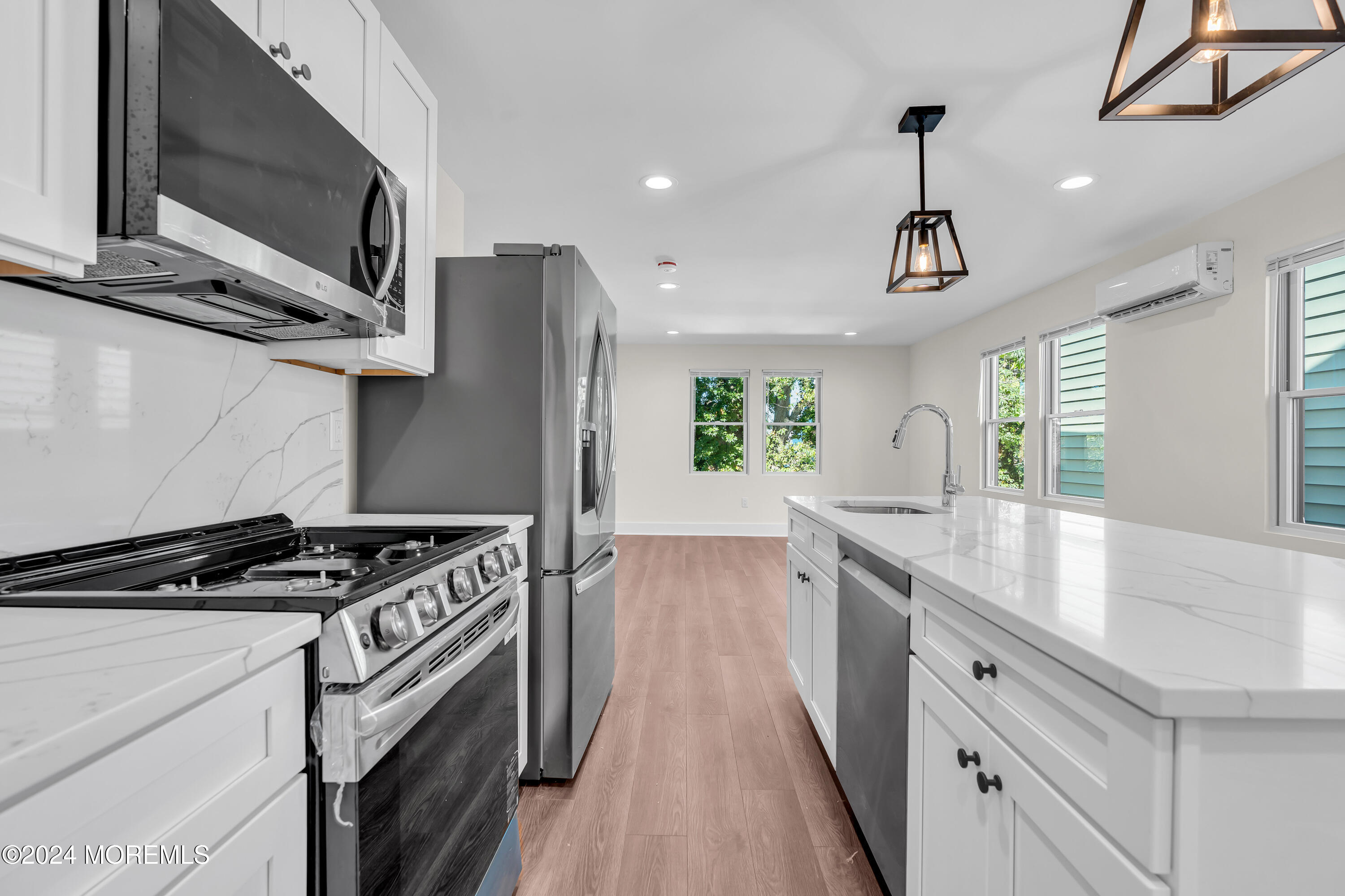 a kitchen with stainless steel appliances granite countertop a sink stove and microwave