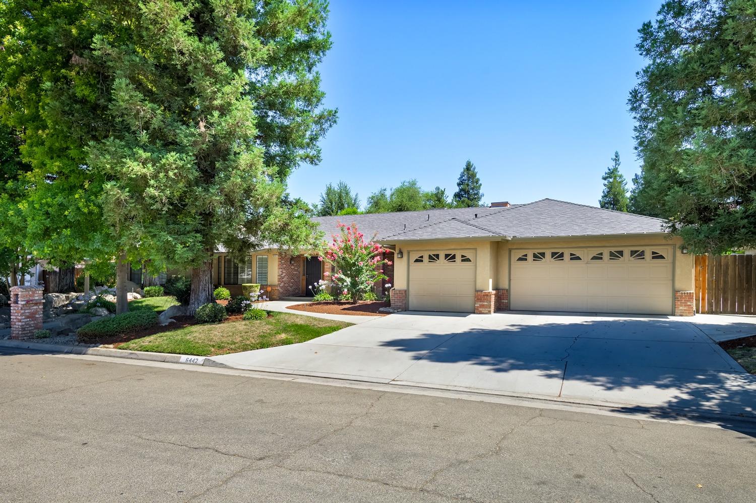 a front view of house with yard and trees in the background