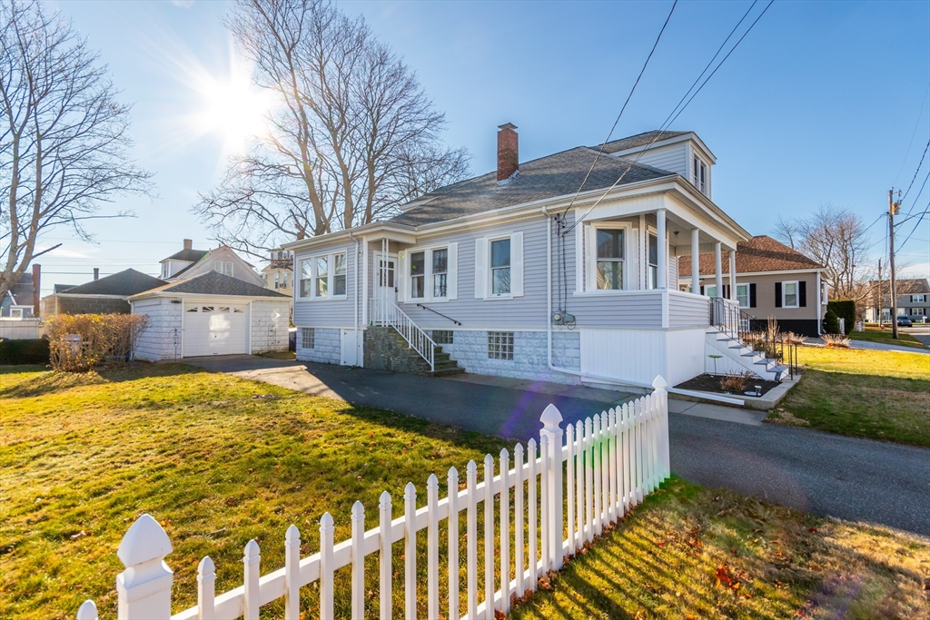 a front view of house with yard and trees in the background