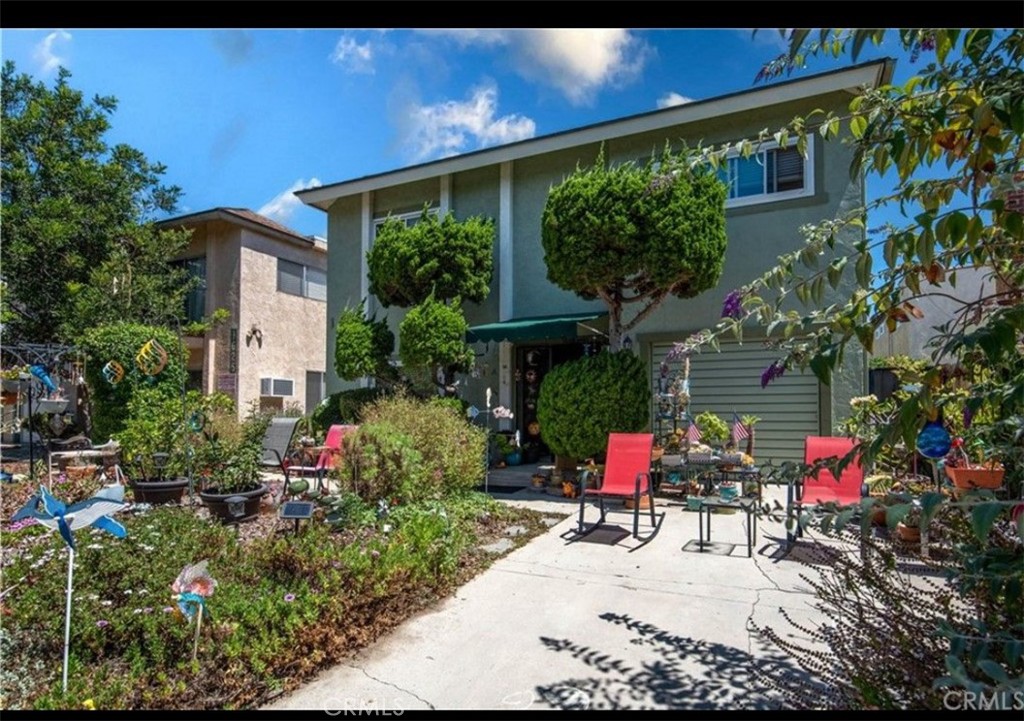 a view of backyard with table and chairs and potted plants