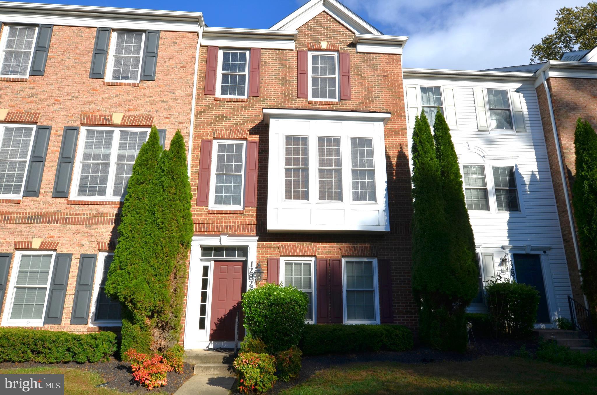 front view of a brick house with a yard