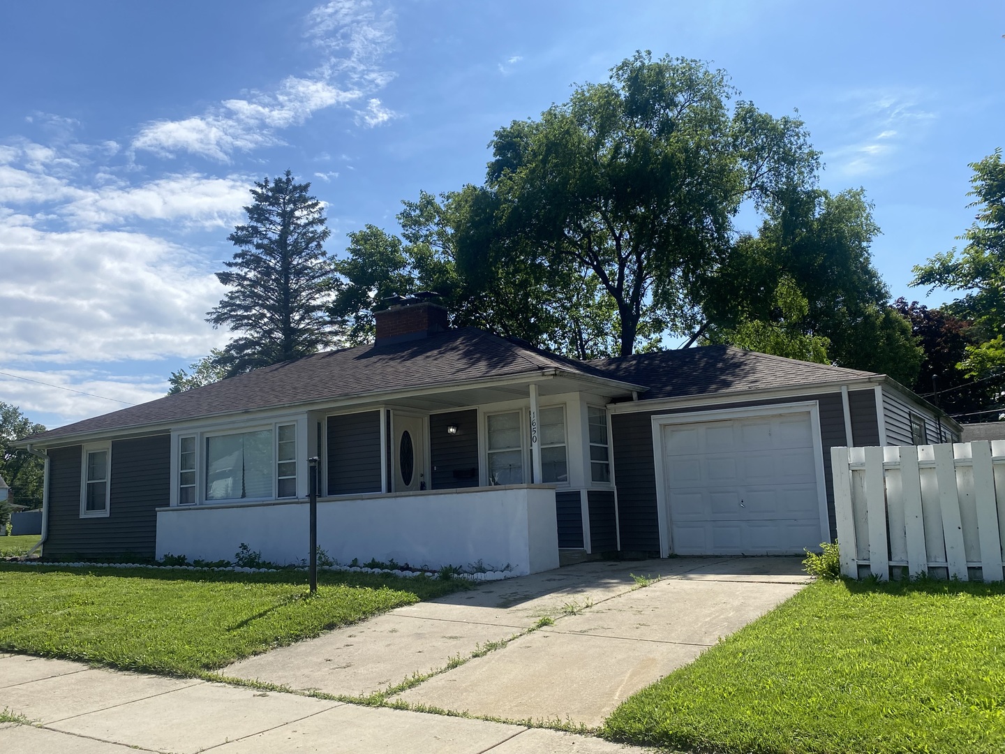 a front view of a house with a garden and trees