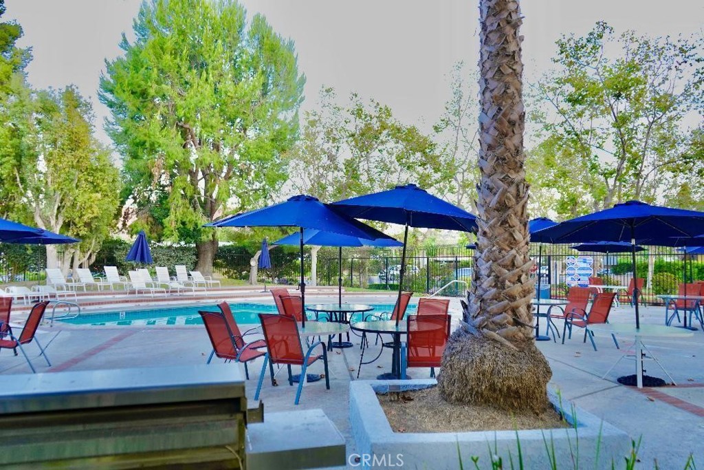 an outdoor sitting area with furniture and umbrella