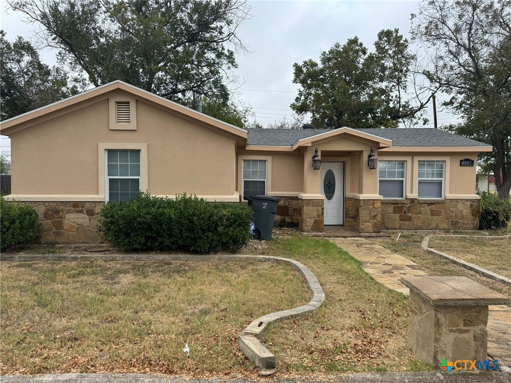 a view of a house with yard and trees in the background