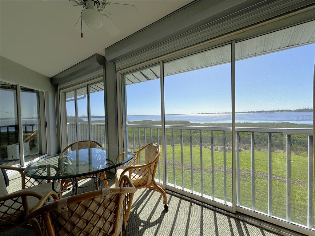 a view of a balcony with chairs and wooden floor