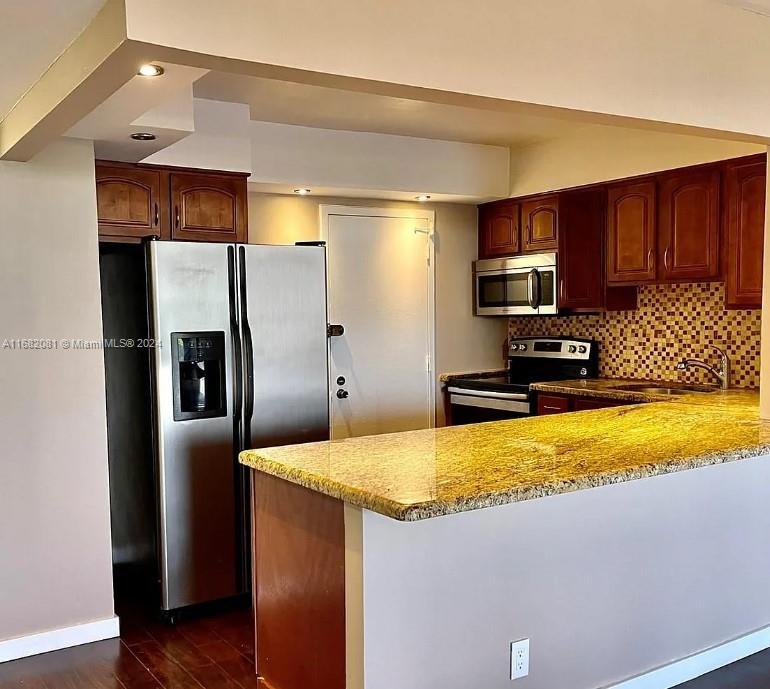 a kitchen with stainless steel appliances granite countertop a refrigerator a sink and a stove