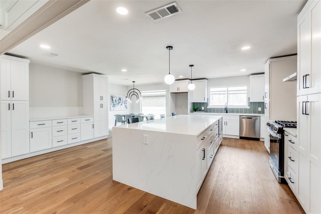 a large kitchen with stainless steel appliances and a large window