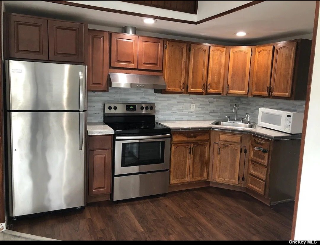 a kitchen with a refrigerator sink and cabinets