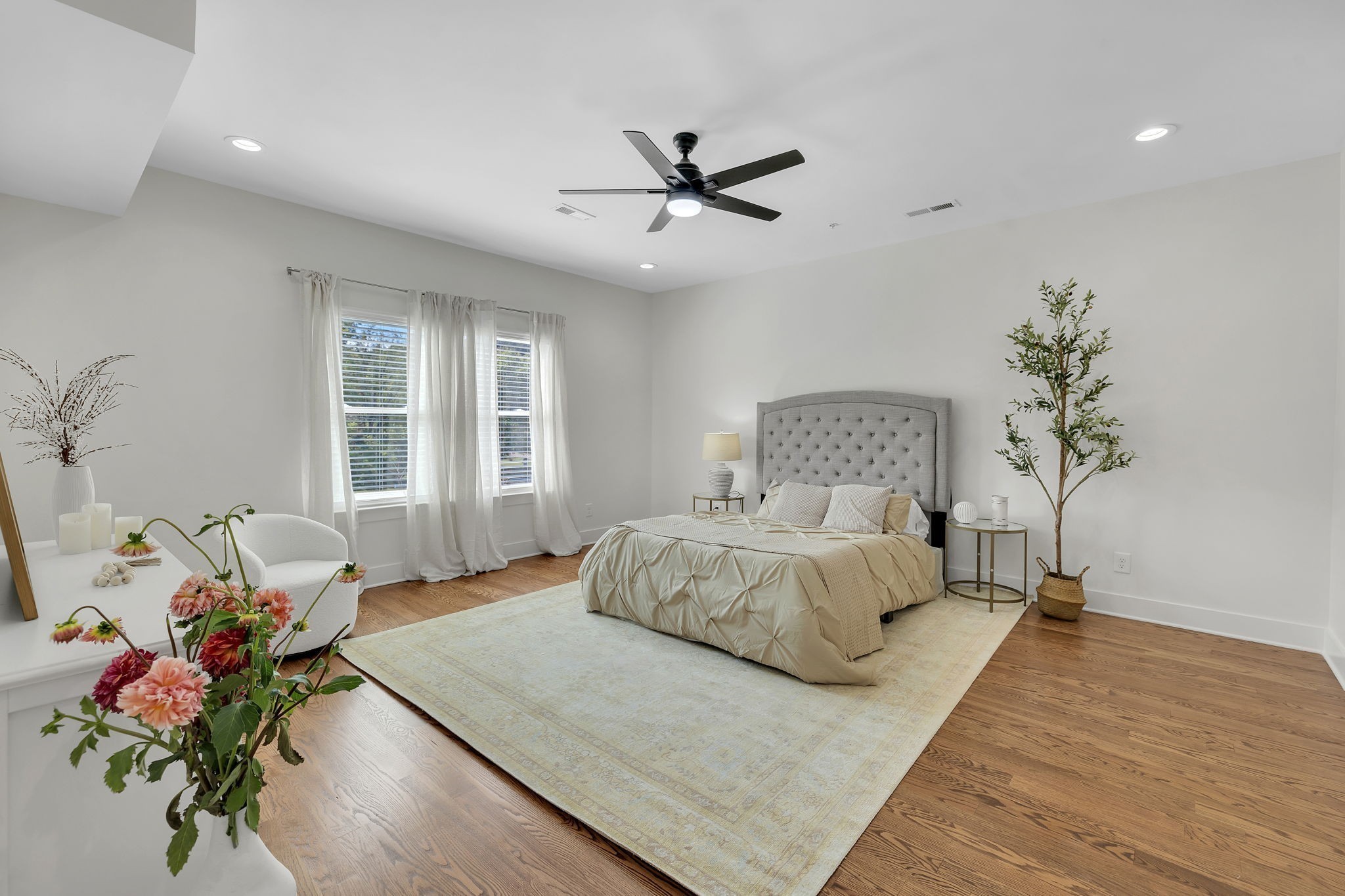 a bedroom with a large bed chandelier and a window