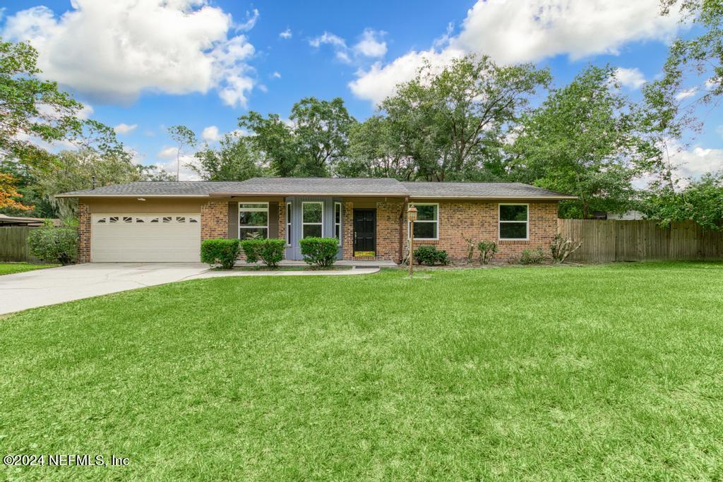 a view of house with yard and green space