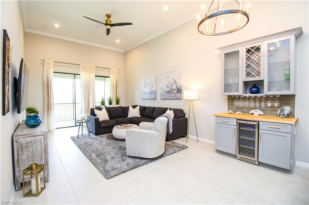 a living room with furniture a chandelier and a flat screen tv