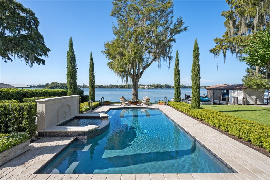 a view of a swimming pool with a garden and trees