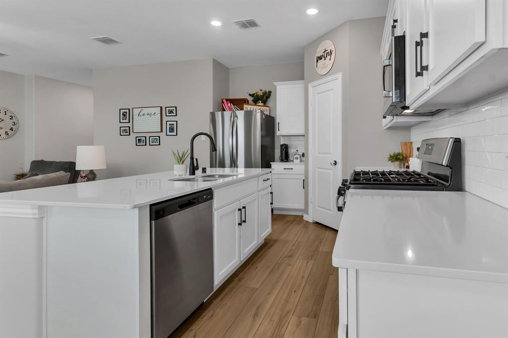 a kitchen with a sink a stove and cabinets