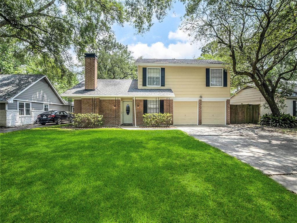 a front view of a house with a yard and green space