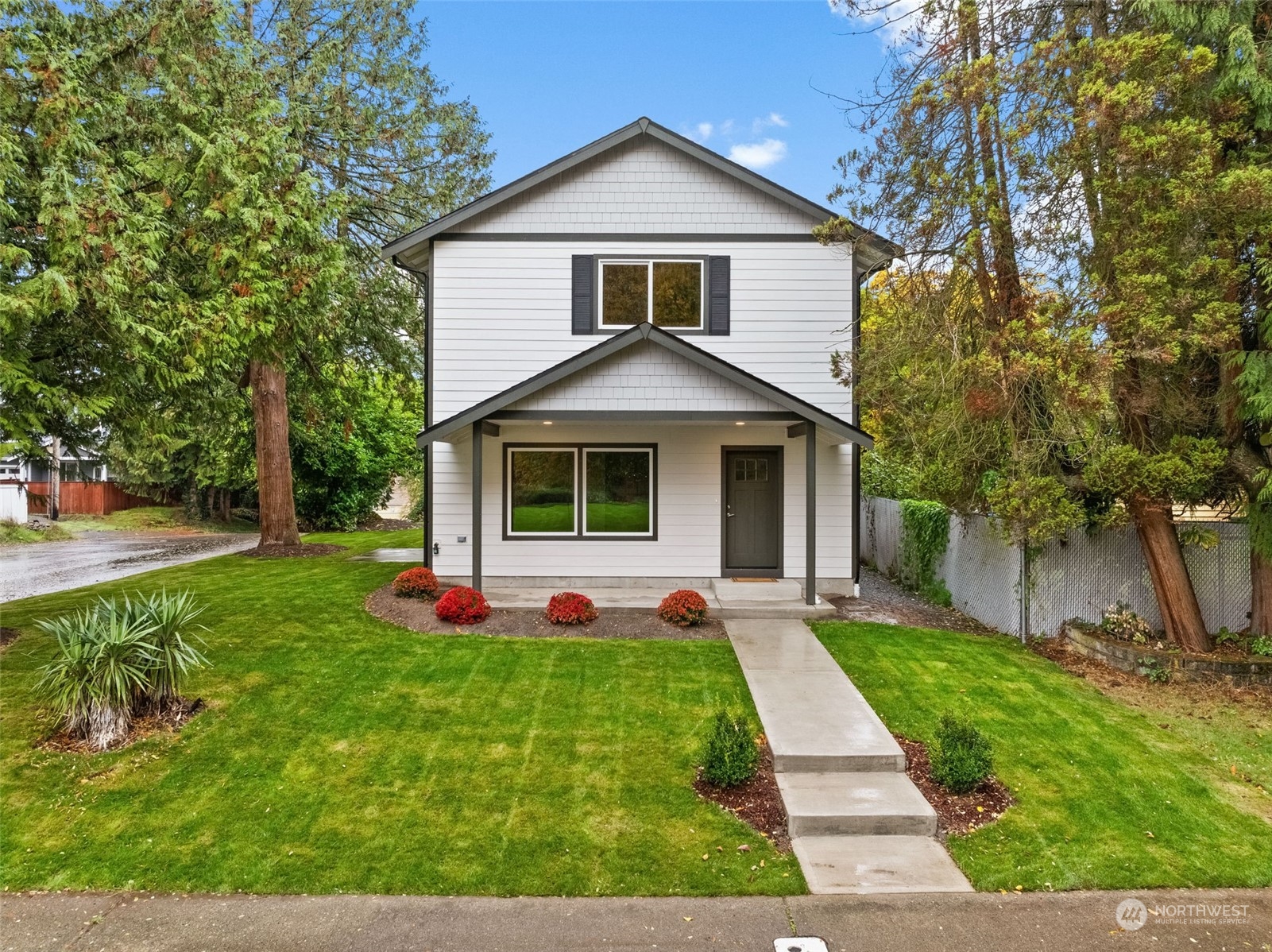 a front view of a house with a yard and trees