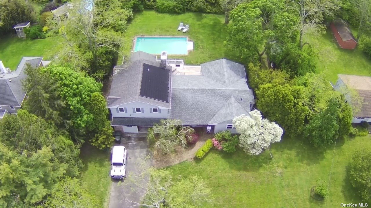 an aerial view of a house with a yard basket ball court and outdoor seating