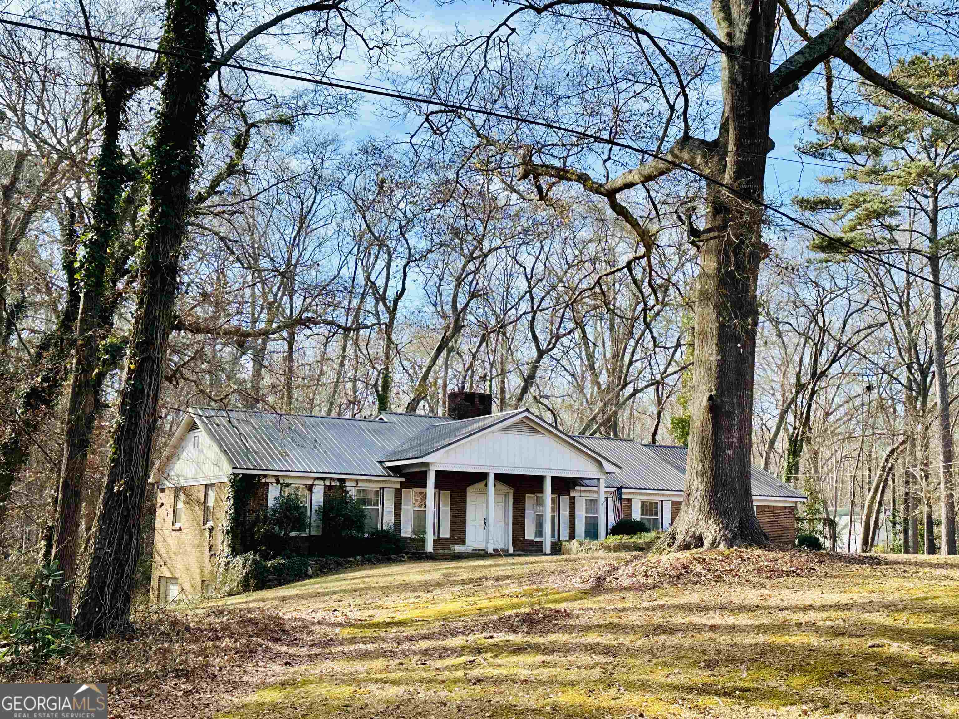 a front view of a house with a yard and large trees