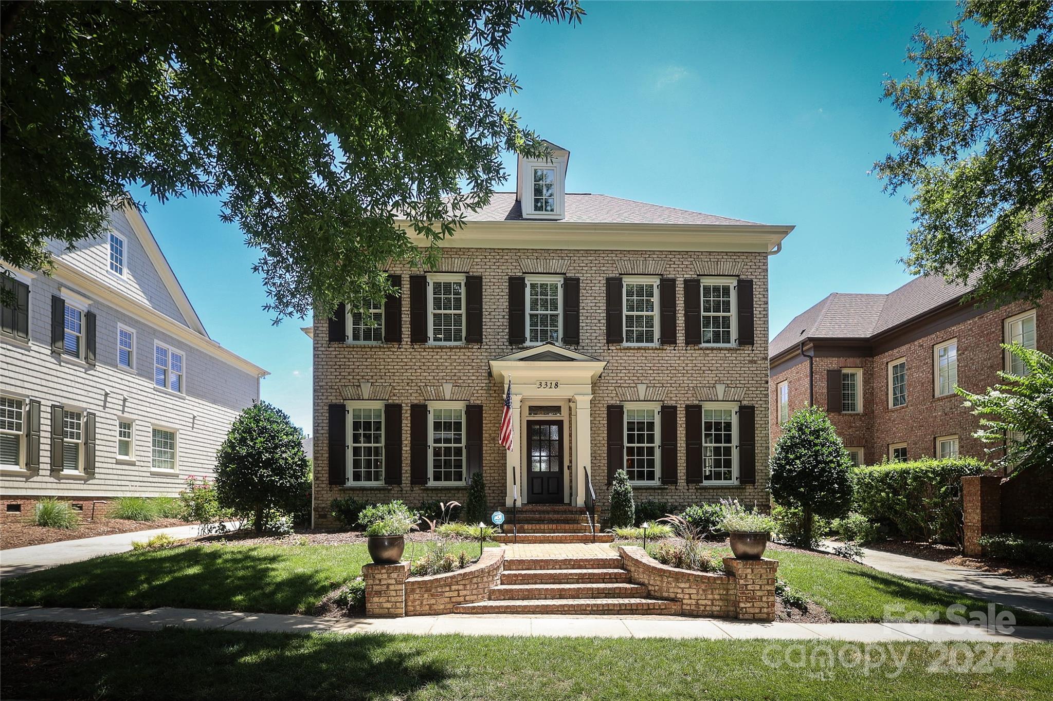 front view of a brick house with a yard