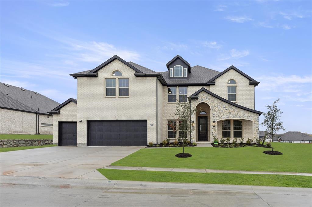 a front view of a house with a yard and garage