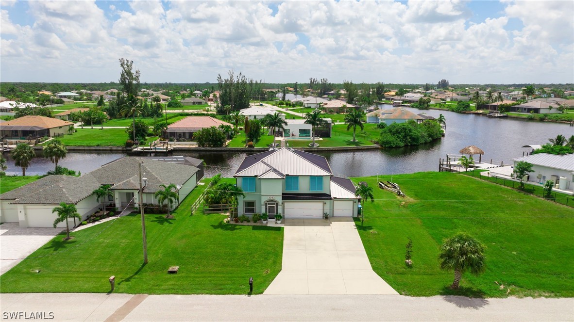 an aerial view of a house with outdoor space and lake view in back