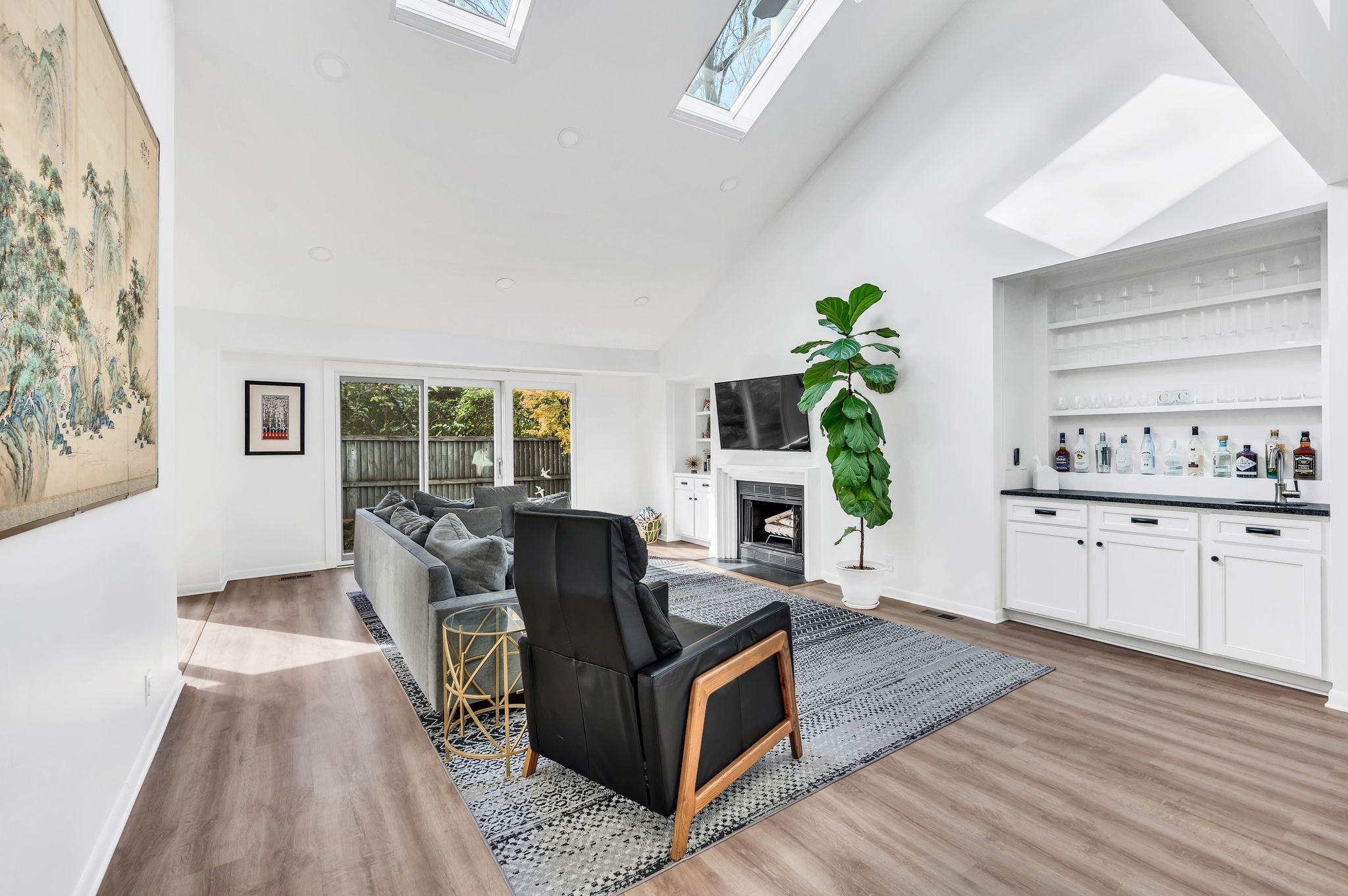 a living room with furniture a fireplace a potted plant and a window