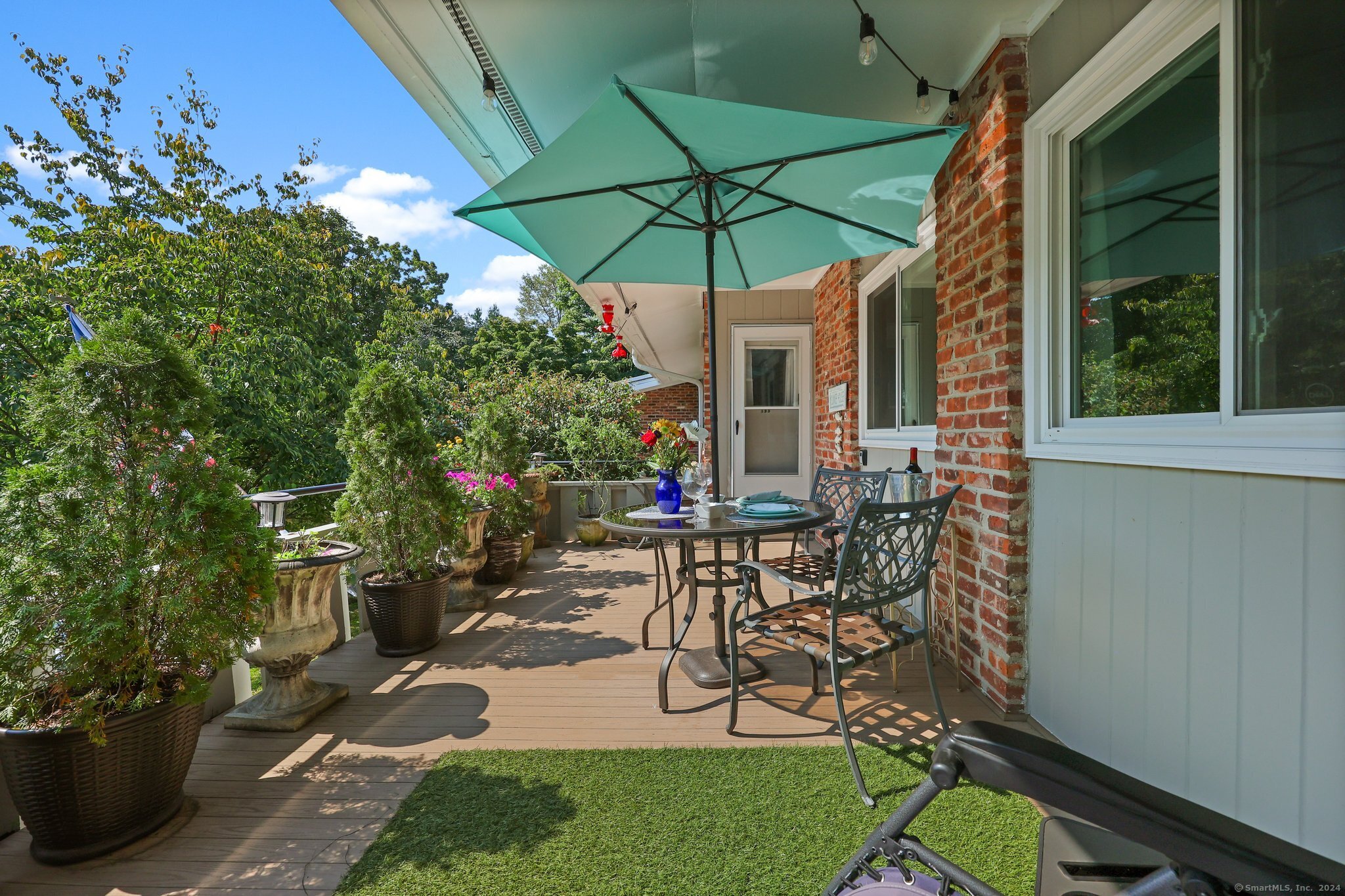 a view of a patio with table and chairs under an umbrella