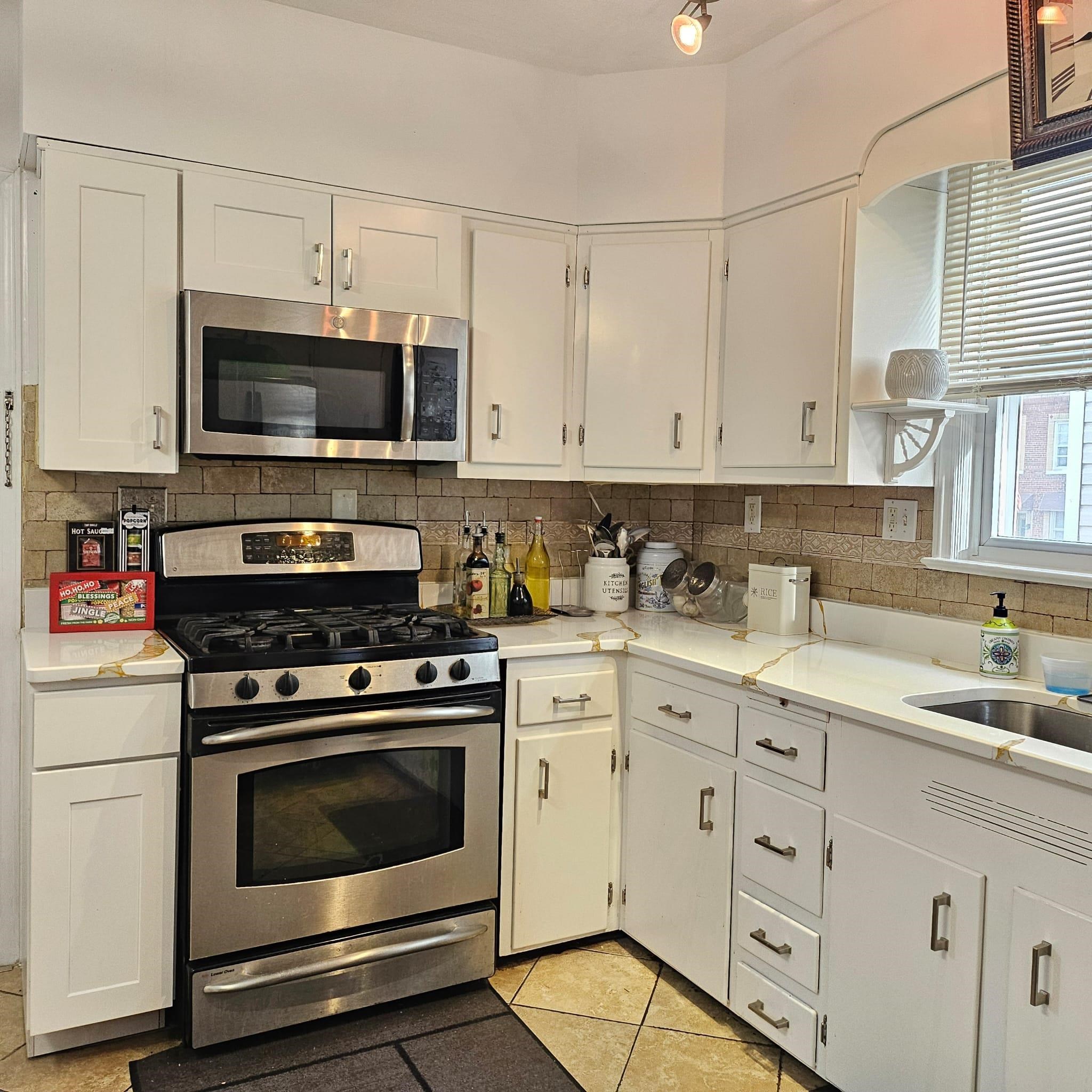 a kitchen with stainless steel appliances granite countertop a stove a sink and a microwave