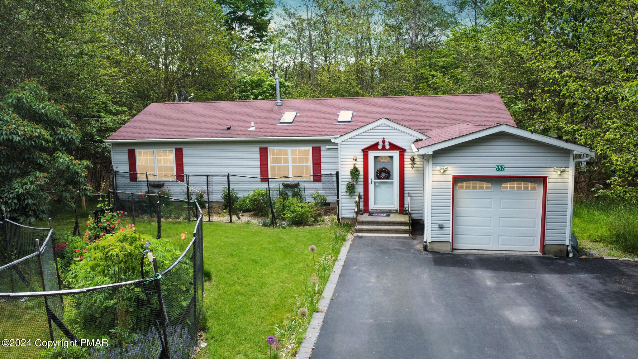 a front view of a house with a garden and yard