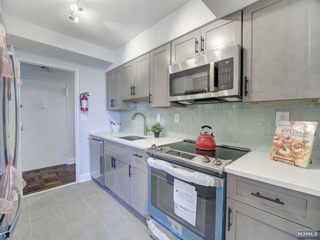 a kitchen with stainless steel appliances granite countertop a sink and a stove