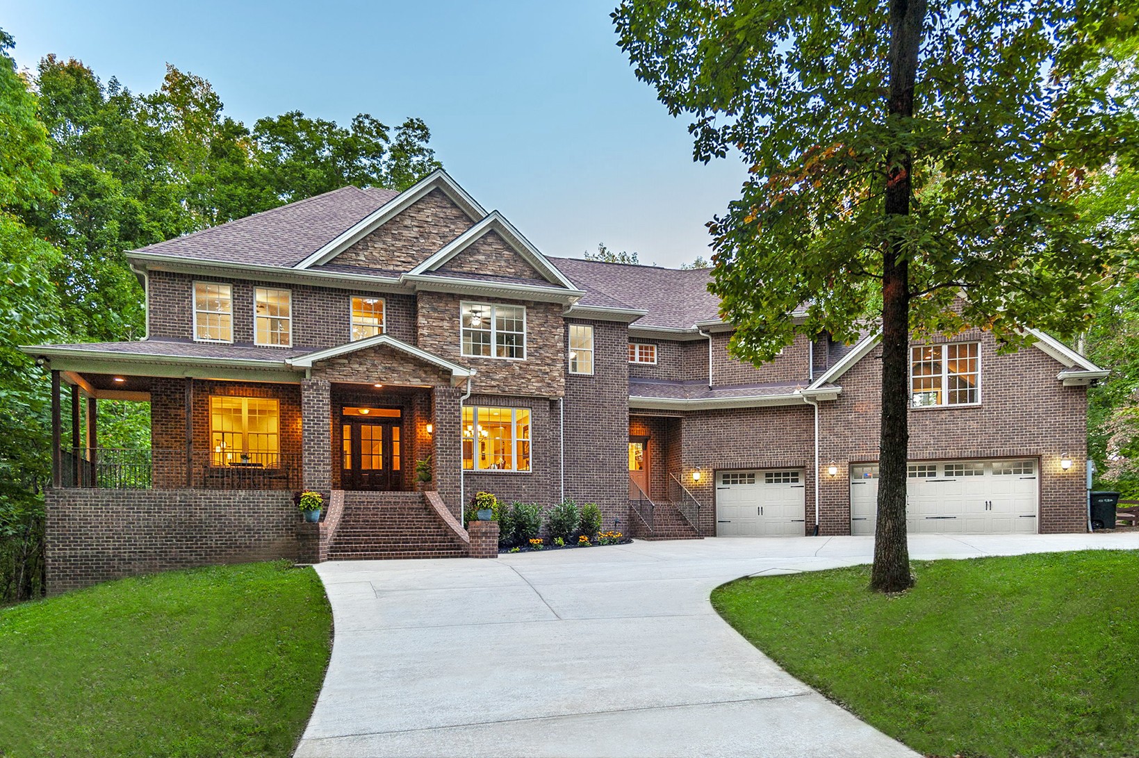 a front view of a house with a yard and trees