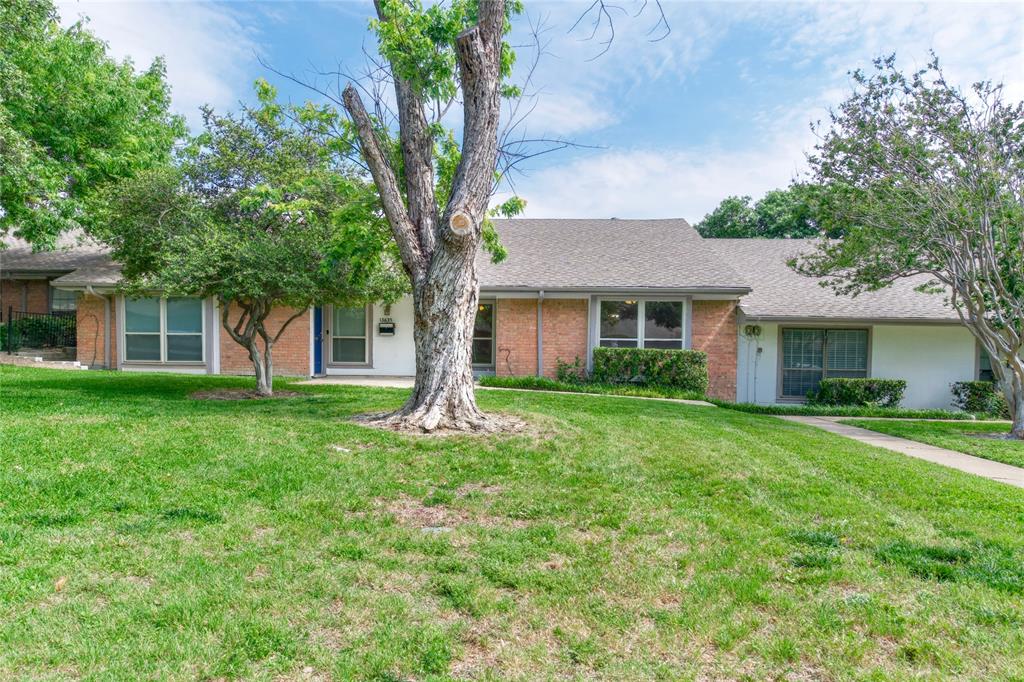 a front view of a house with a yard and trees