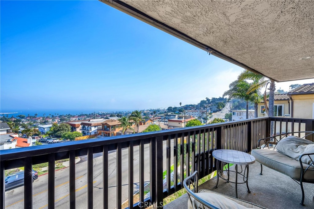 a view of a city from a balcony with outdoor seating