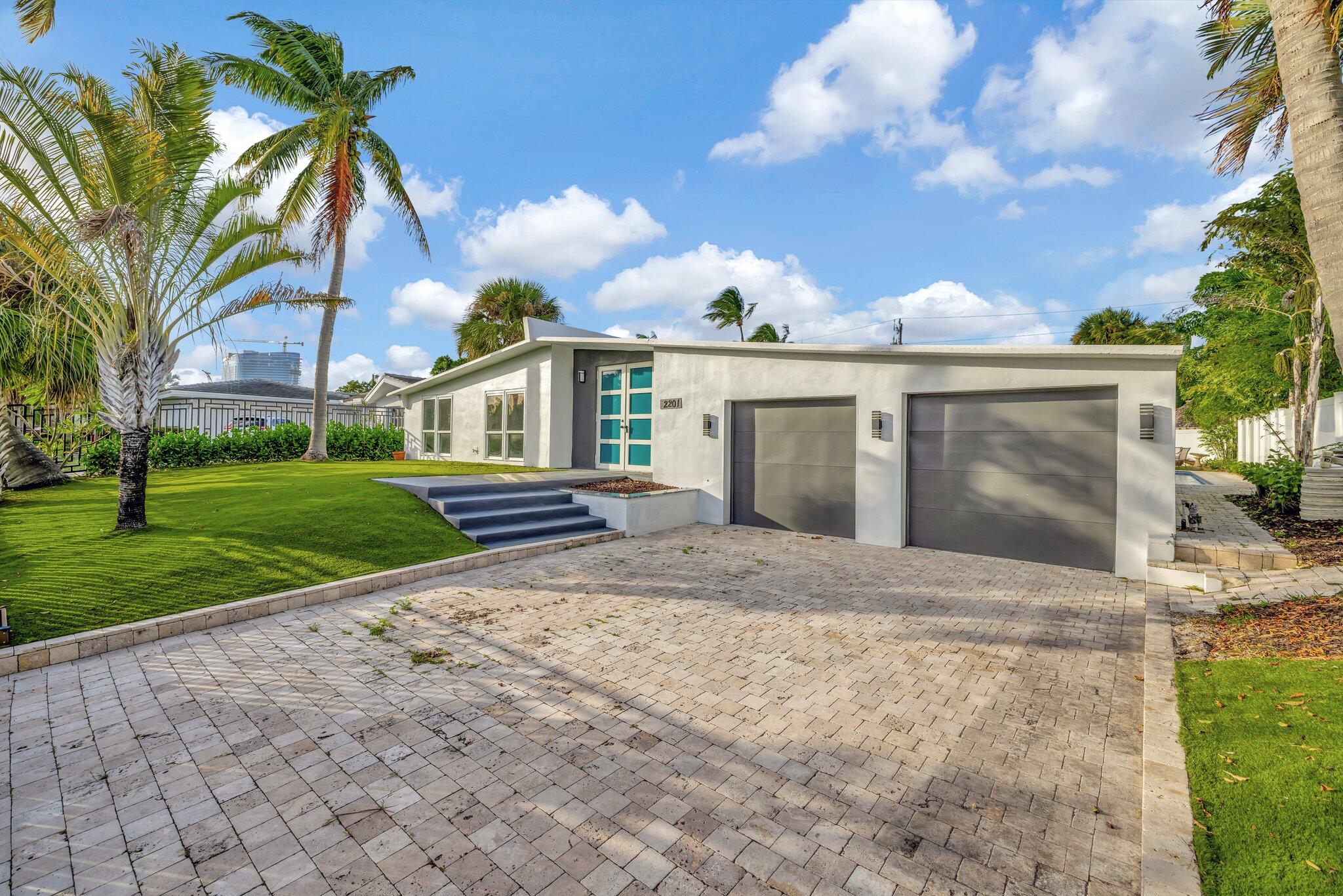 a view of a house with a yard and large tree