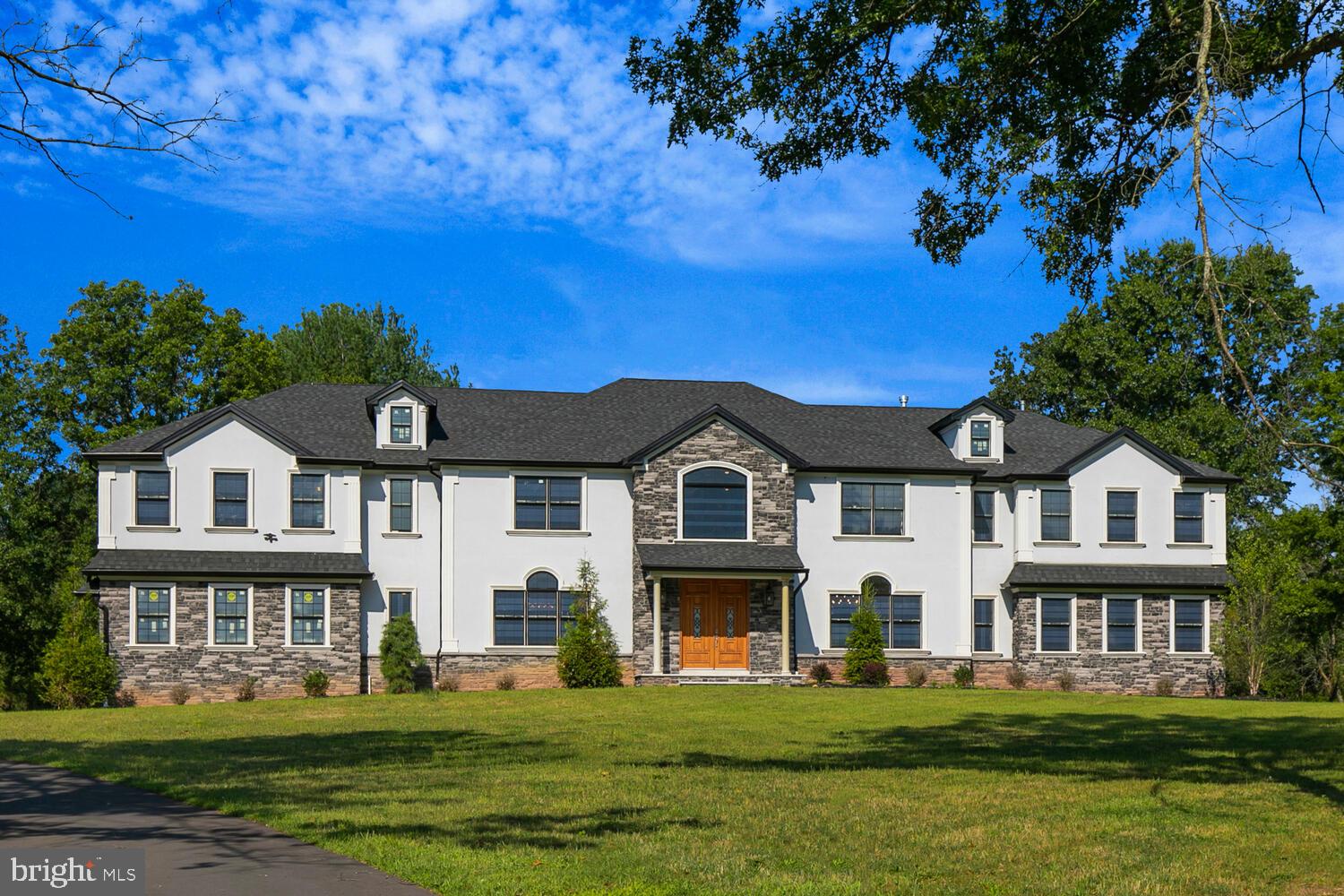 a front view of a house with a garden and trees