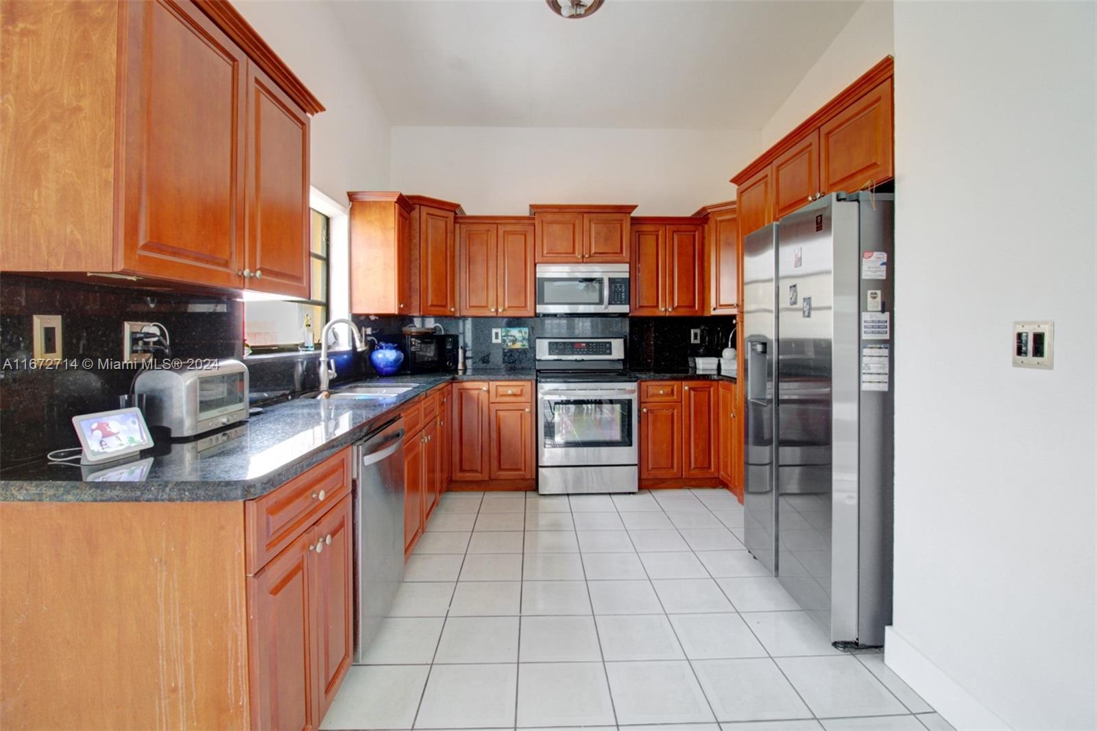 a kitchen with stainless steel appliances granite countertop a stove a sink and a refrigerator