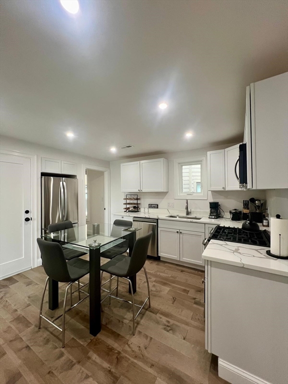 a kitchen with a dining table chairs and white cabinets