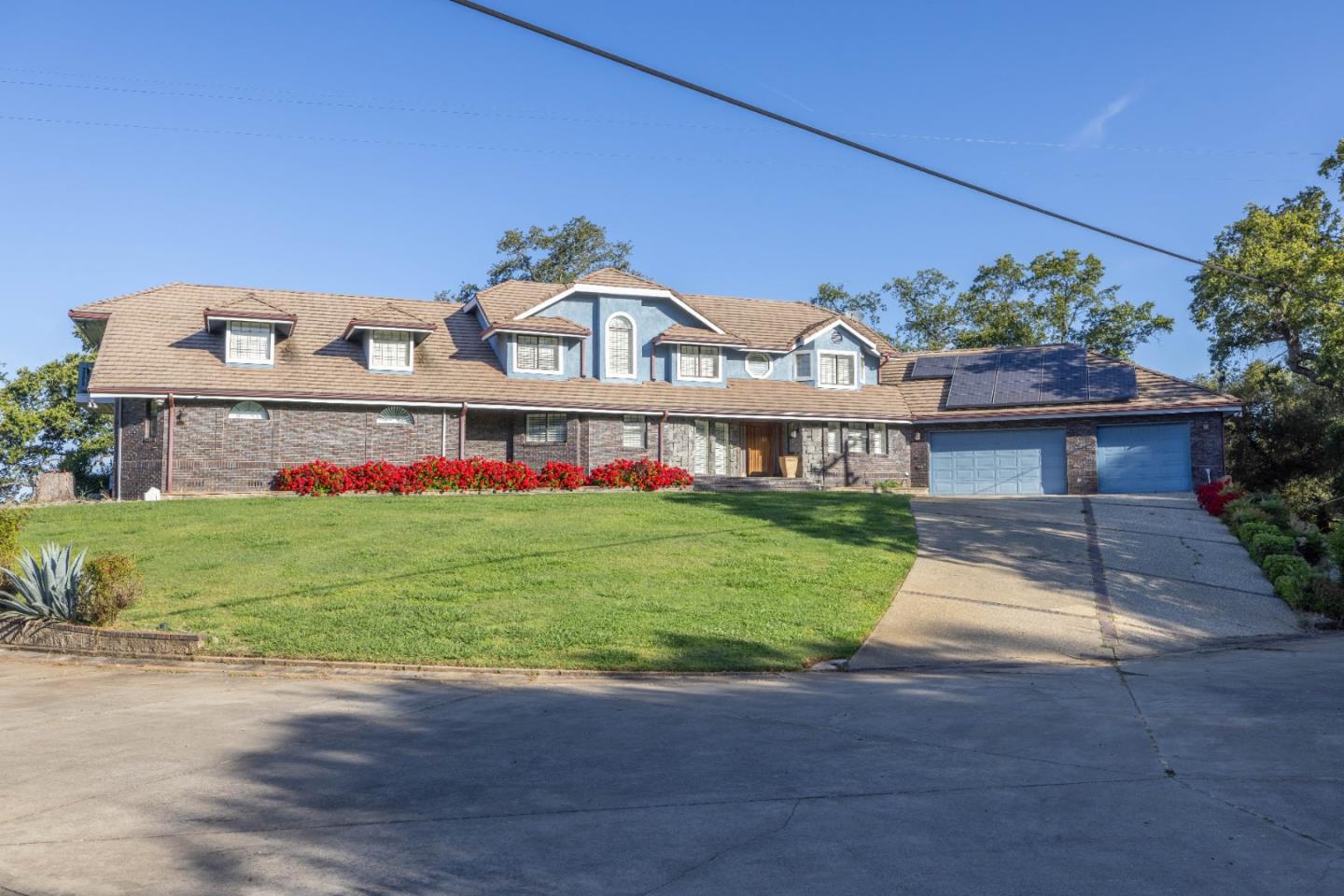 a front view of a house with a garden and yard