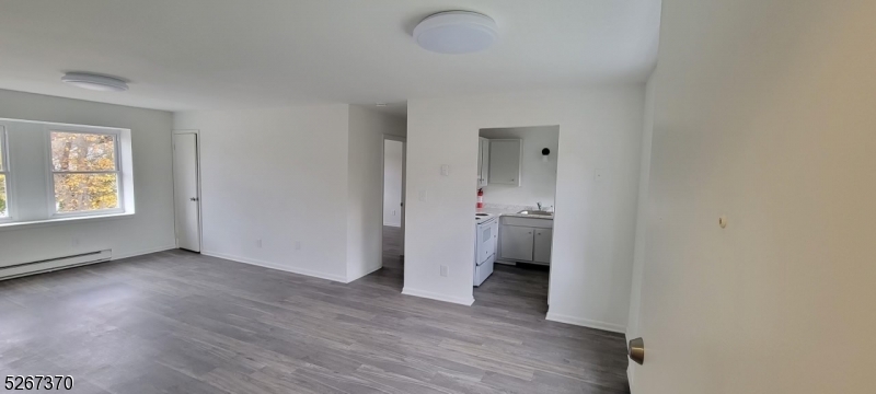 a view of a room with wooden floor and a bathroom