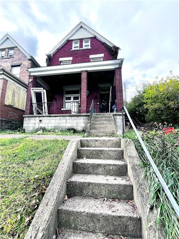 a view of a house with a yard and stairs