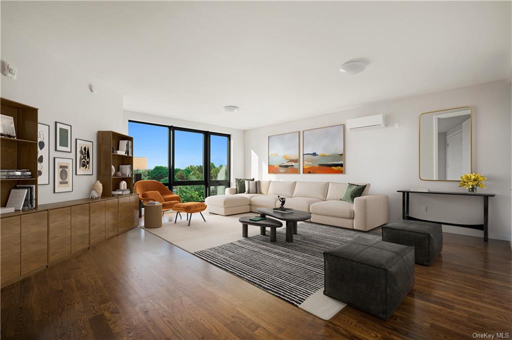 a living room with furniture kitchen view and a wooden floor