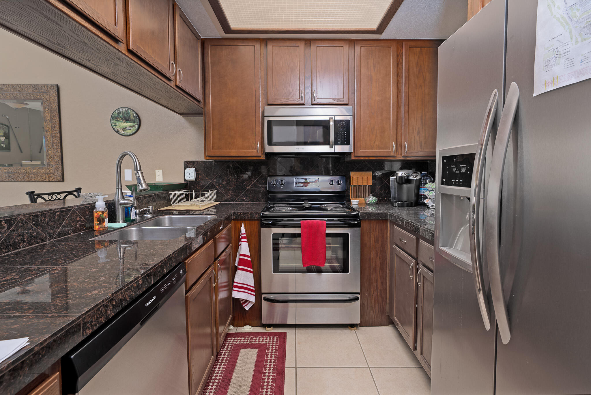 a kitchen with stainless steel appliances granite countertop a refrigerator and a stove