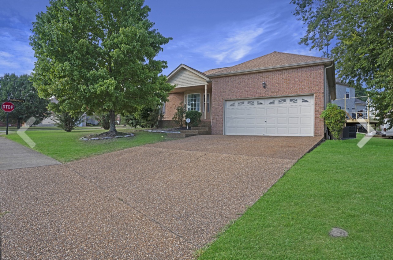 a view of a house with a yard and garage