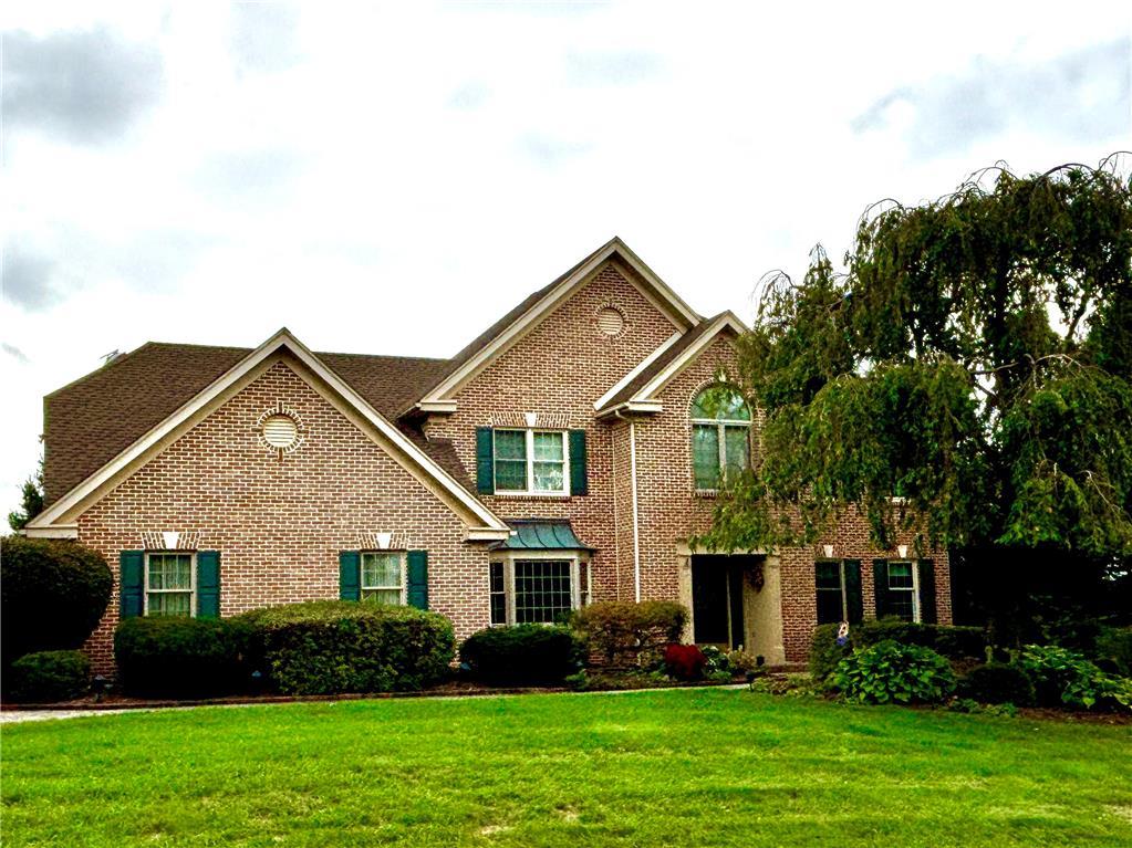 a front view of a house with a yard and trees