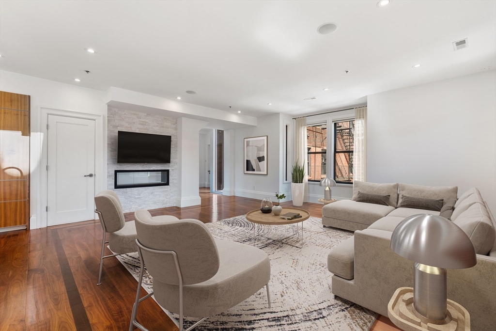 a living room with furniture a flat screen tv and a large window