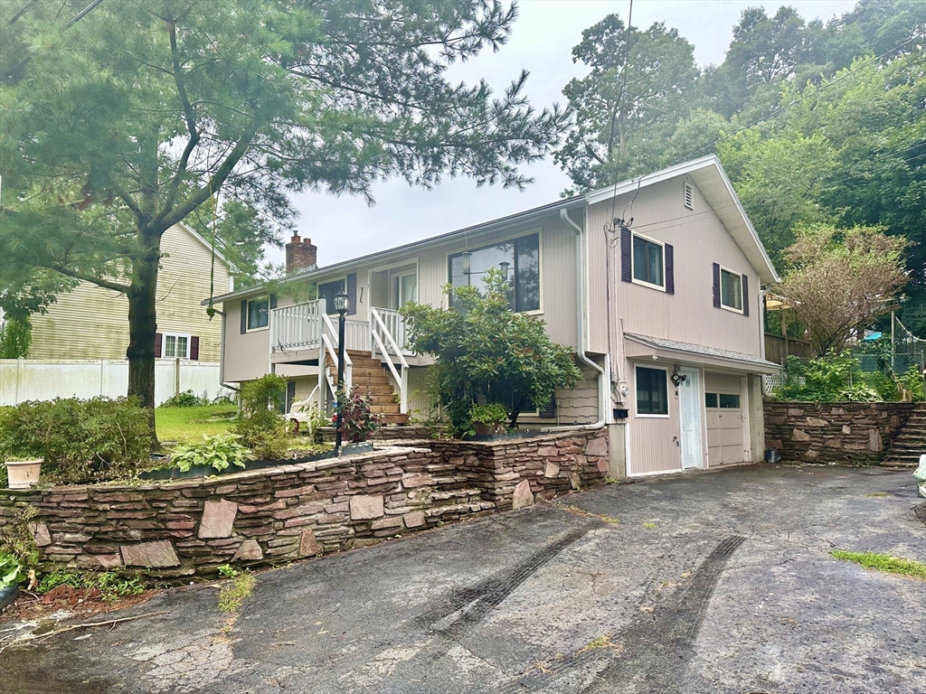 a front view of a house with a yard and potted plants