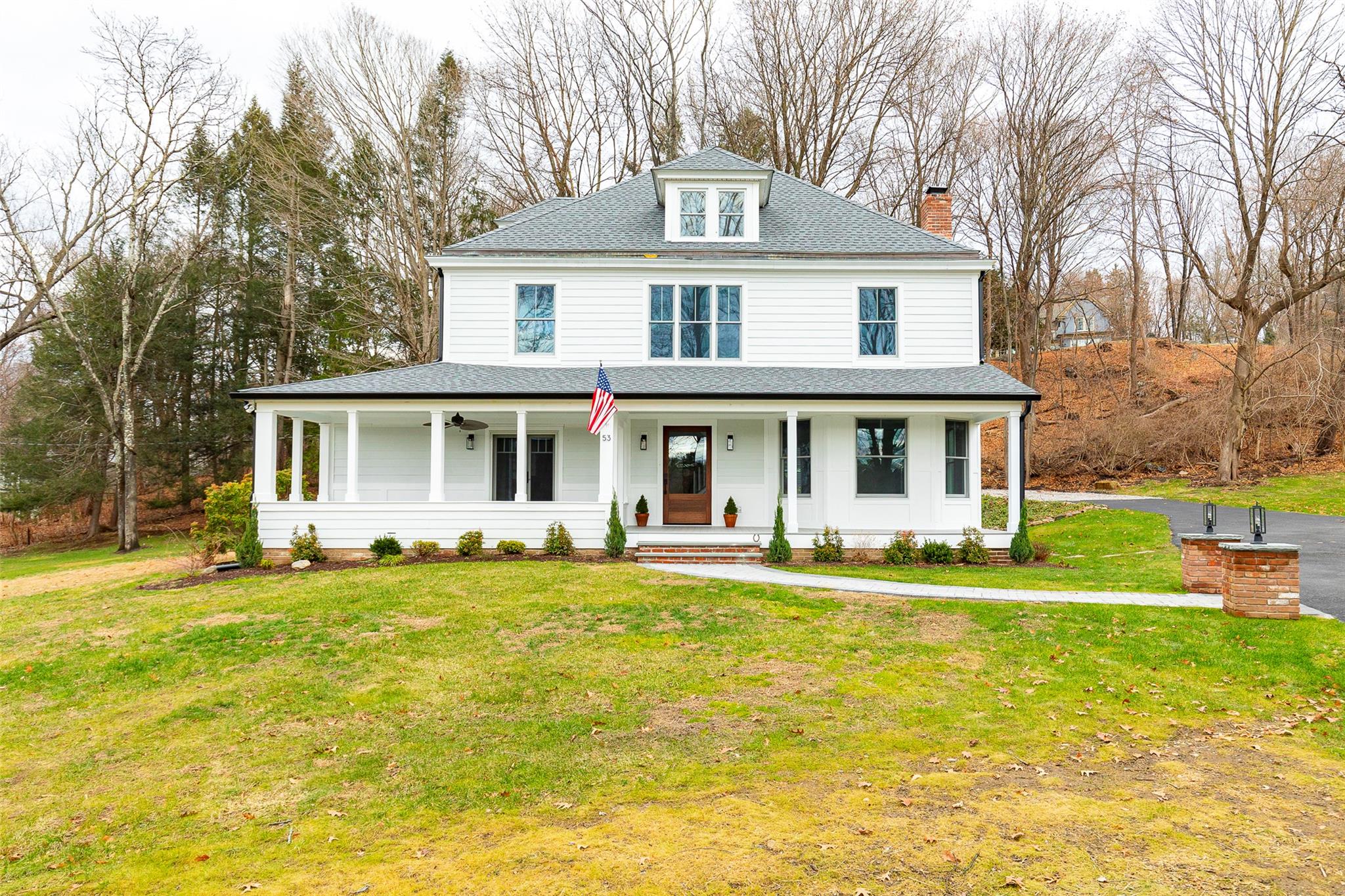 Farmhouse inspired home with covered porch and a front lawn